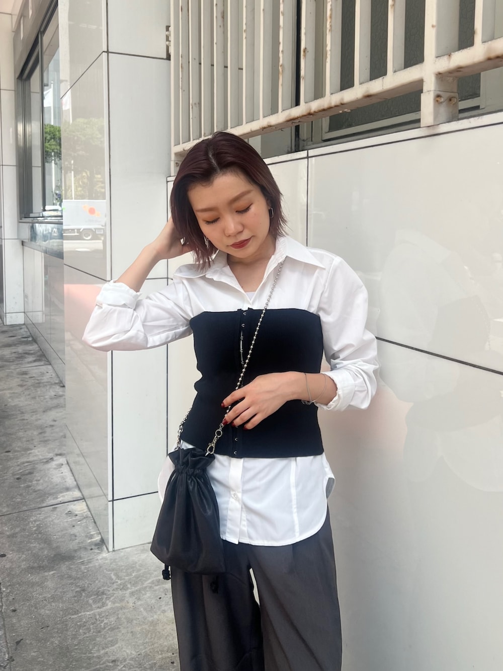 ブラック系のブーツ、ホワイト系のシャツ/ブラウス、ブラック系のニット/セーターを着用したレディースの秋コーディネートの5枚目の写真