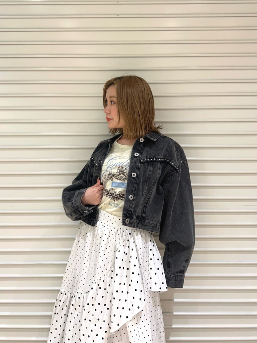 イエロー系のTシャツ/カットソー、ブラック系のデニムジャケット、ホワイト系のスカートを着用したレディースの春コーディネートの4枚目の写真