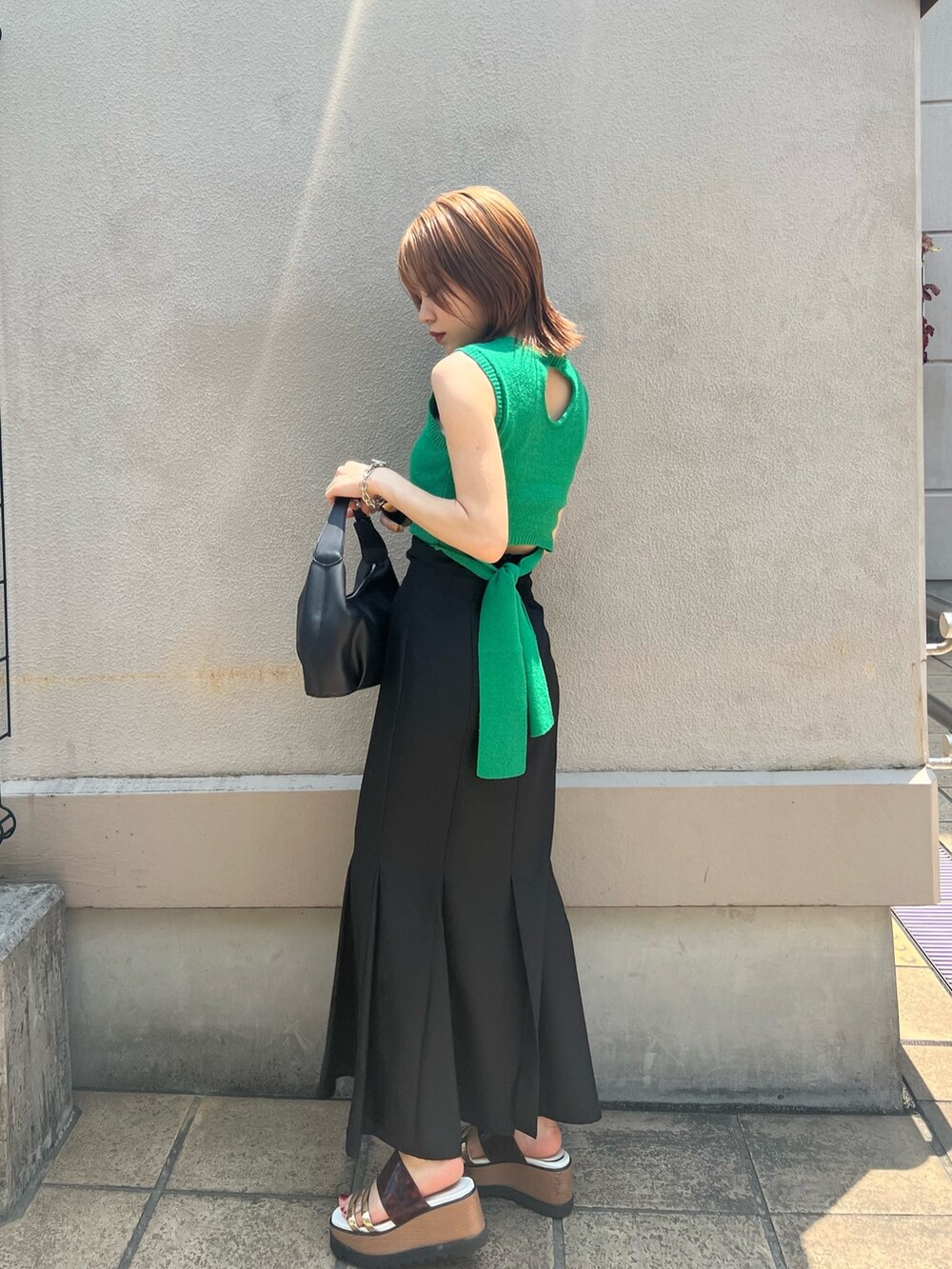 グリーン系のタンクトップ、ブラック系のスカート、その他のサンダルを着用したレディースの夏コーディネートの7枚目の写真