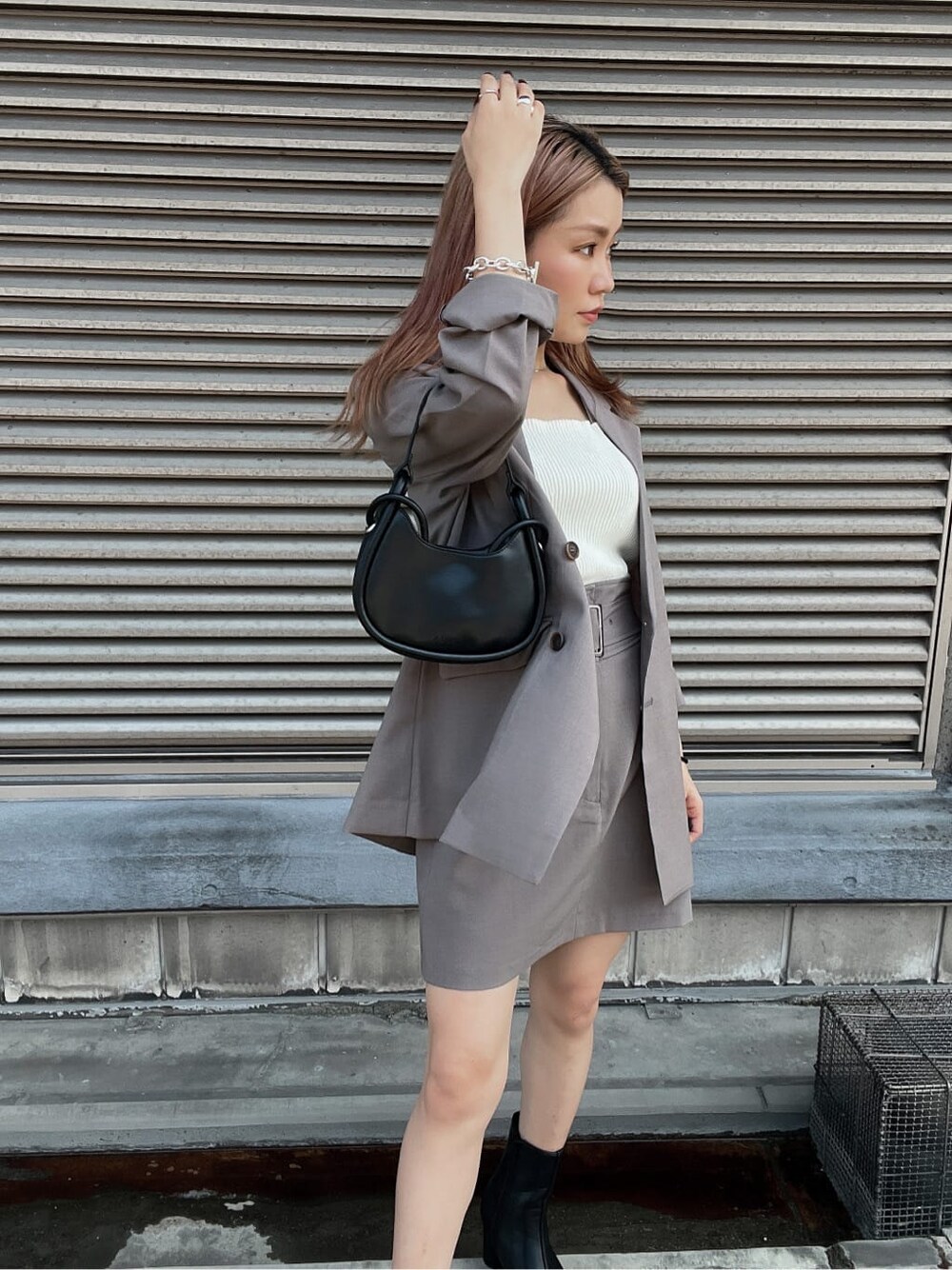 ホワイト系のタンクトップ、グレー系のテーラードジャケット、グレー系のスカートを着用したレディースの夏コーディネートの6枚目の写真