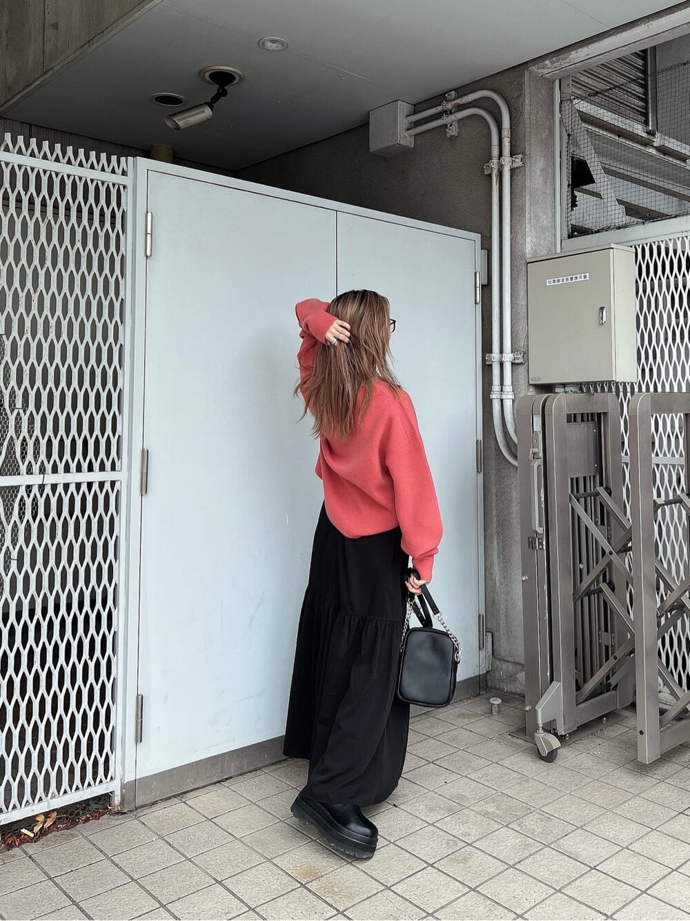 ブラック系のスカート、ブラック系のショルダーバッグ、ピンク系のニット/セーターを着用したレディースの秋コーディネートの7枚目の写真