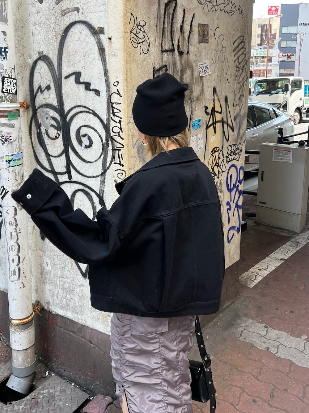 イエロー系のTシャツ/カットソー、ブラック系のデニムジャケット、グレー系のスカートを着用したレディースの春コーディネートの6枚目の写真