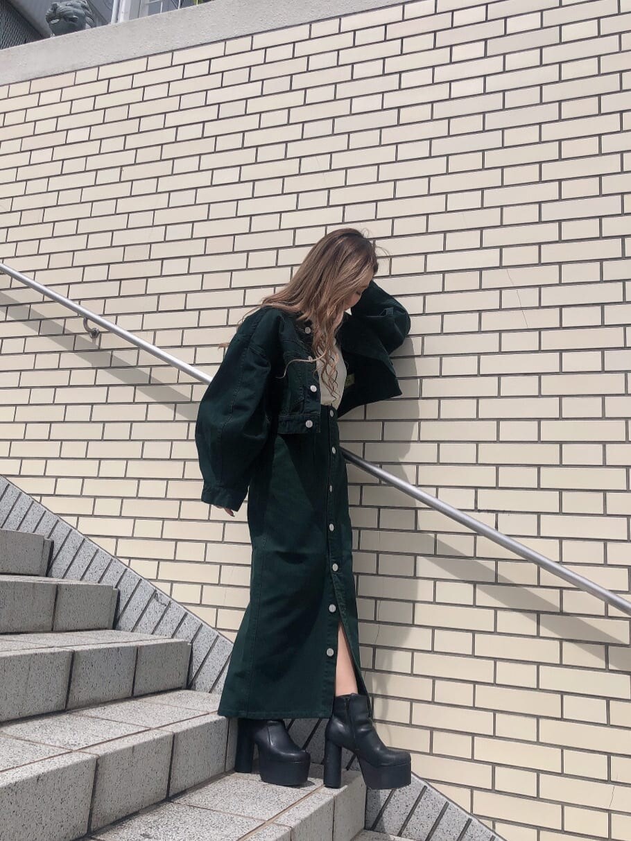 グリーン系のブルゾン、グリーン系のスカート、ホワイト系のTシャツ/カットソーを着用したレディースの秋コーディネートの2枚目の写真