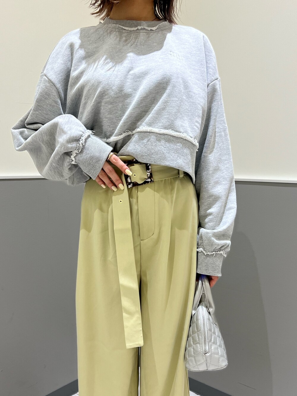 グレー系のスウェット、グリーン系のその他パンツ、シルバー系のハンドバッグを着用したレディースの冬コーディネートの7枚目の写真