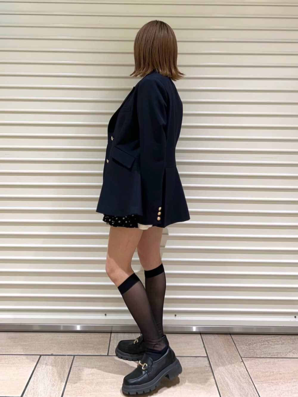 グレー系のニット/セーター、ブラック系のその他パンツ、ブルー系のノーカラージャケットを着用したレディースの冬コーディネートの2枚目の写真