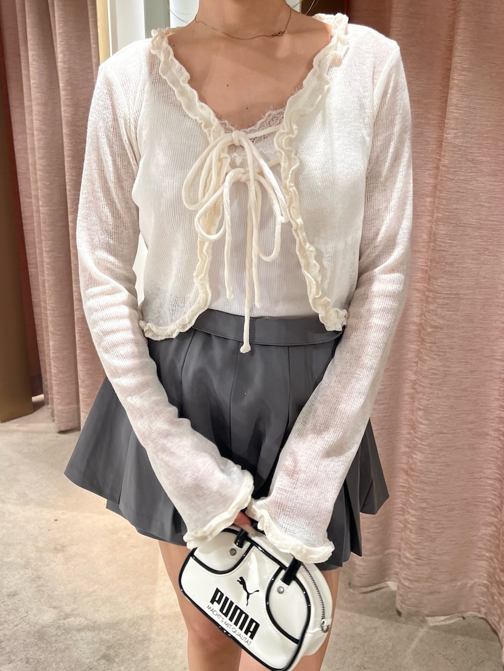 ホワイト系のカーディガン/ボレロ、ブラック系のローファー、グレー系のスカートを着用したレディースの秋コーディネートの5枚目の写真