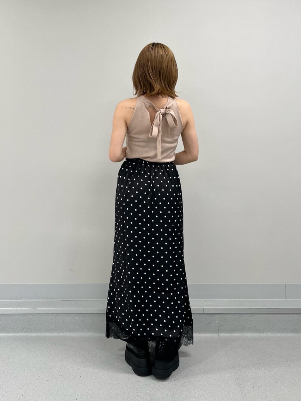 ブラック系のスカート、ピンク系のキャミソールを着用したレディースの夏コーディネートの3枚目の写真