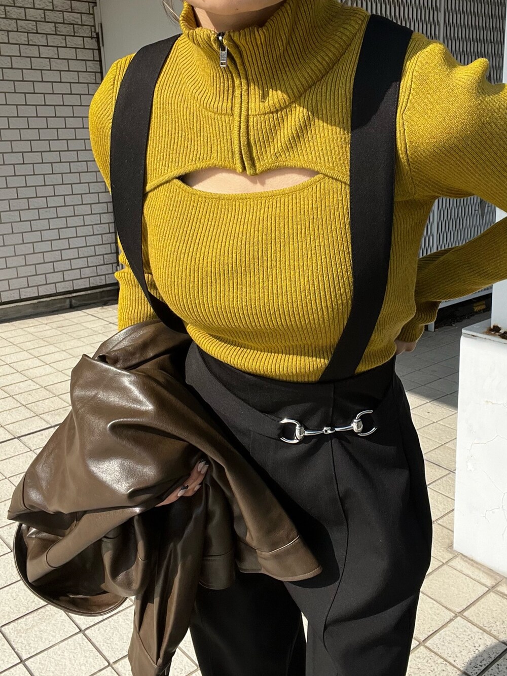 ブラウン系のライダースジャケット、ブラック系のスラックス、ブラック系のローファーを着用したレディースの秋コーディネートの3枚目の写真