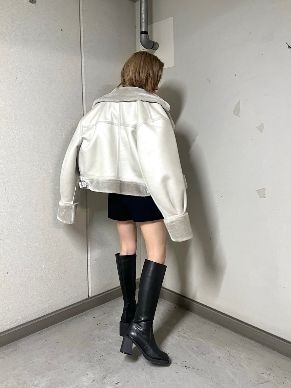 ブルー系のニット/セーター、グレー系のムートンコート、ブラック系のその他パンツを着用したレディースの秋コーディネートの3枚目の写真