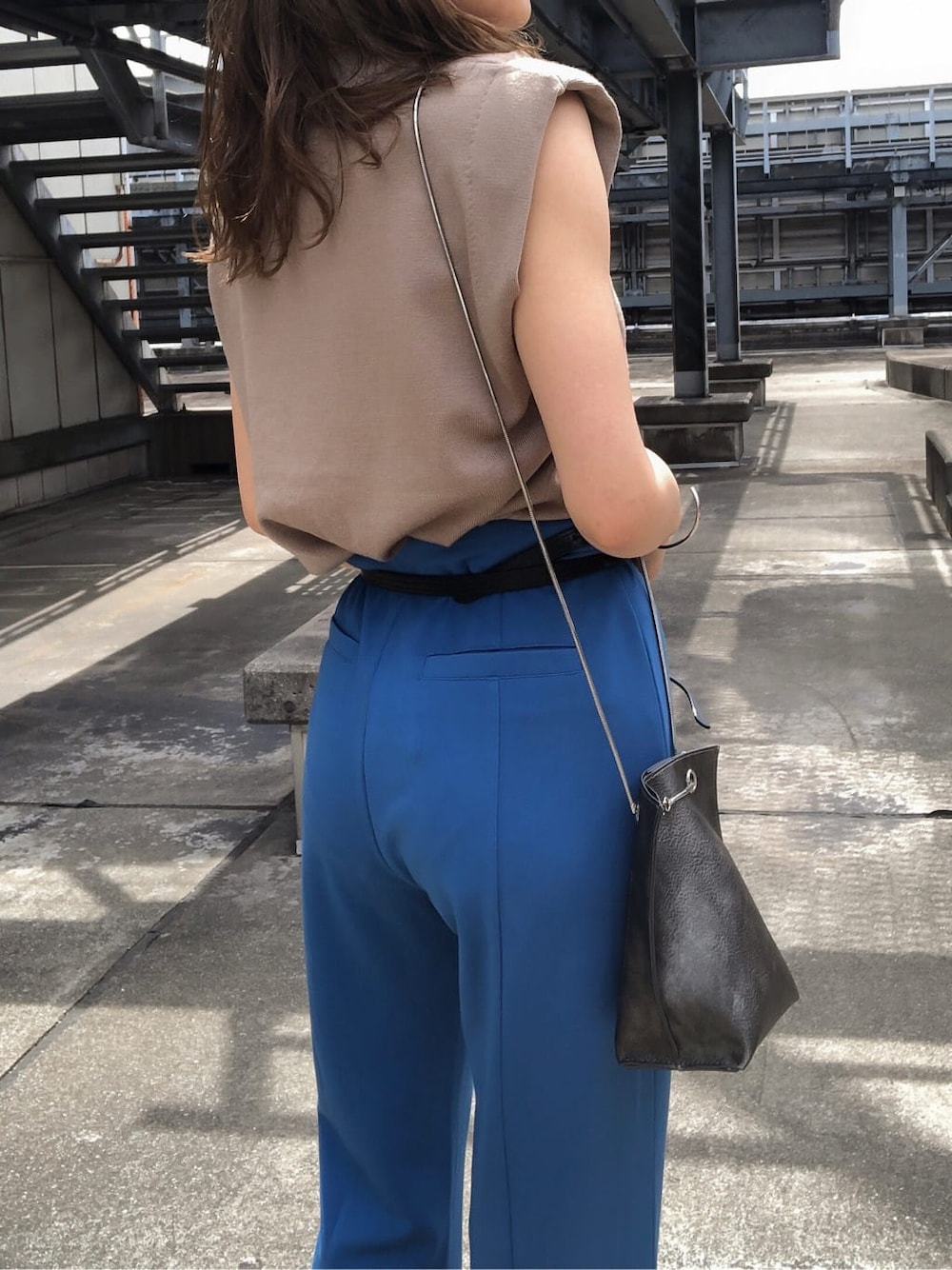 ブルー系のスラックス、ブラック系のサンダル、ベージュ系のタンクトップを着用したレディースの夏コーディネートの7枚目の写真