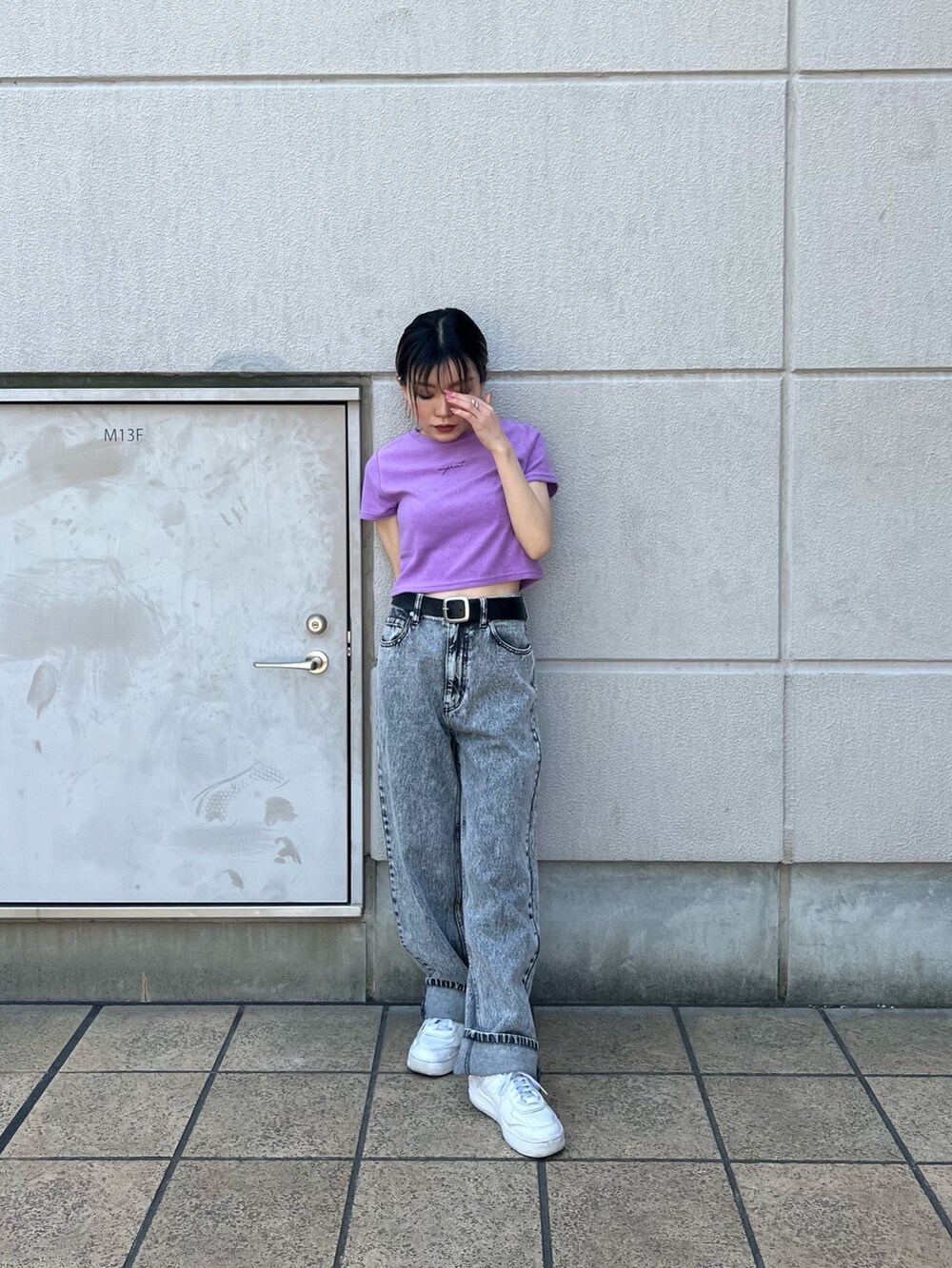 グレー系のデニムパンツ、パープル系のTシャツ/カットソー、ブラック系のベルトを着用したレディースの春コーディネートの2枚目の写真