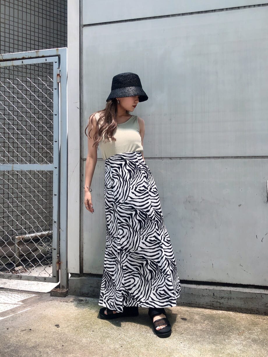 ブラック系のサンダル、その他のスカート、ベージュ系のTシャツ/カットソーを着用したレディースの夏コーディネートの2枚目の写真