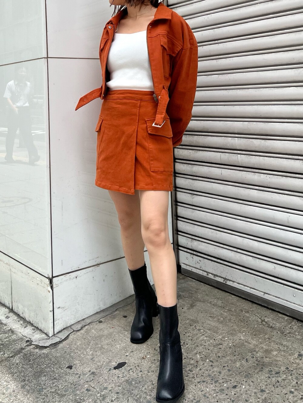 ホワイト系のニット/セーター、オレンジ系のデニムジャケット、オレンジ系のスカートを着用したレディースの夏コーディネートの4枚目の写真