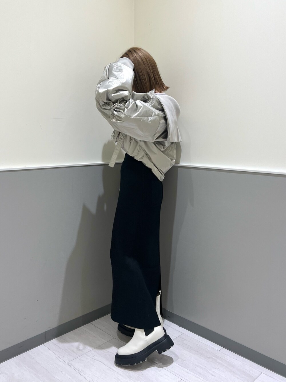 ブラック系のニット/セーター、シルバー系のブルゾン、ブラック系のスカートを着用したレディースの冬コーディネートの3枚目の写真