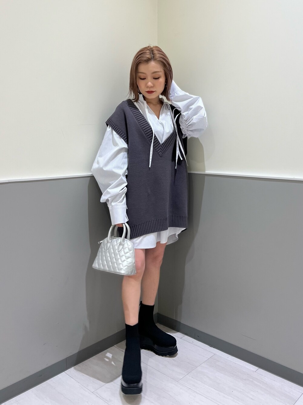 グレー系のベスト、シルバー系のハンドバッグ、その他のシャツ/ブラウスを着用したレディースの冬コーディネートの2枚目の写真