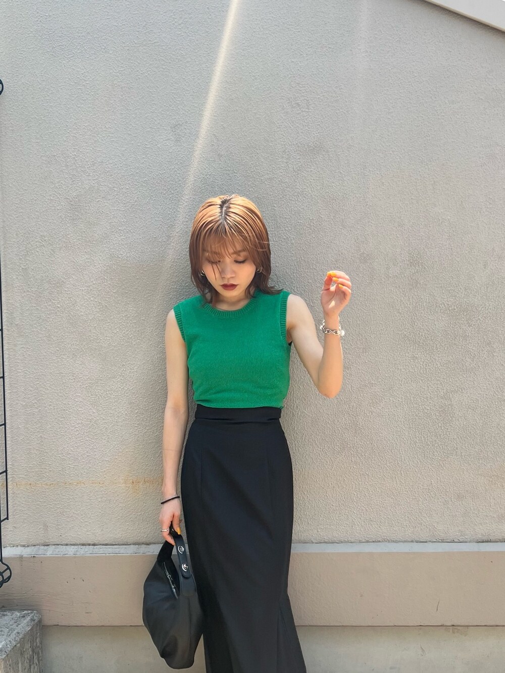 グリーン系のタンクトップ、ブラック系のスカート、その他のサンダルを着用したレディースの夏コーディネートの6枚目の写真