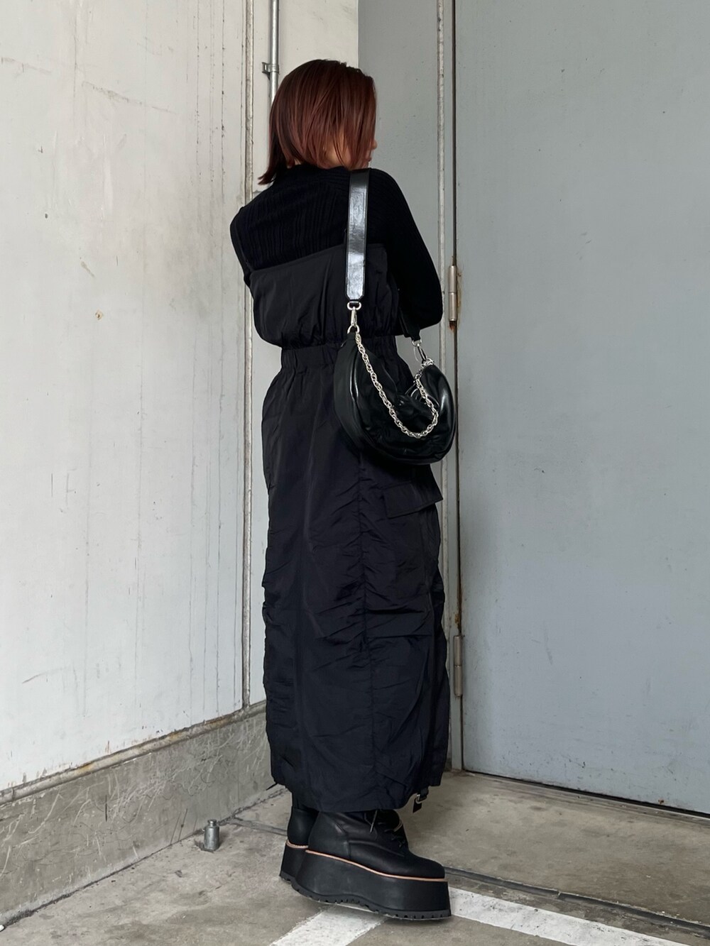 ブラック系のワンピース、ブラック系のブーツ、ブラック系のニット/セーターを着用したレディースの冬コーディネートの3枚目の写真