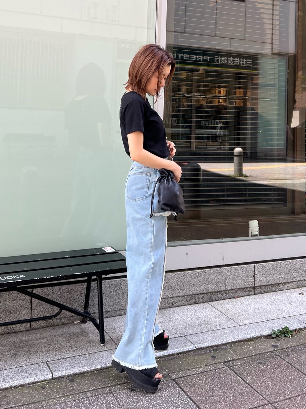 ブラック系のTシャツ/カットソー、ブルー系のデニムパンツ、ブラック系のショルダーバッグを着用したレディースの夏コーディネートの3枚目の写真