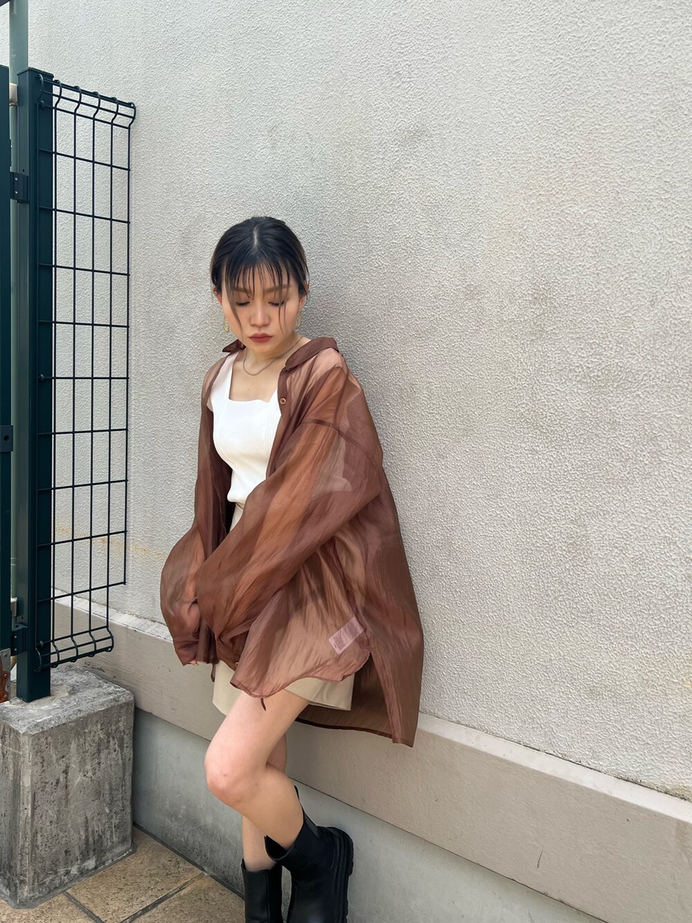 ベージュ系のスラックス、ブラウン系のシャツ/ブラウス、ホワイト系のタンクトップを着用したレディースの春コーディネートの4枚目の写真