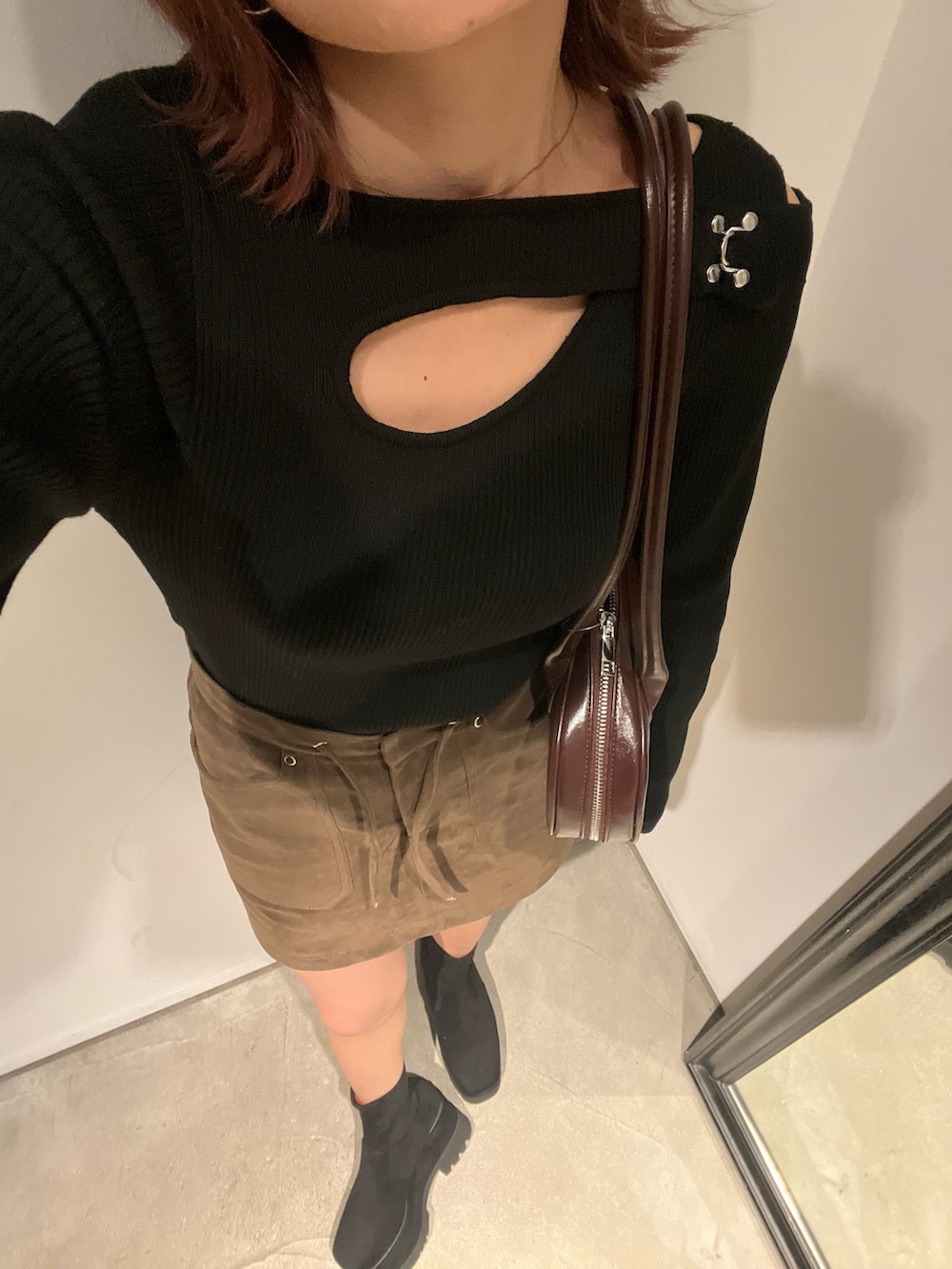 ブラック系のブーツ、ブラウン系のスカート、ブラック系のニット/セーターを着用したレディースの冬コーディネートの7枚目の写真