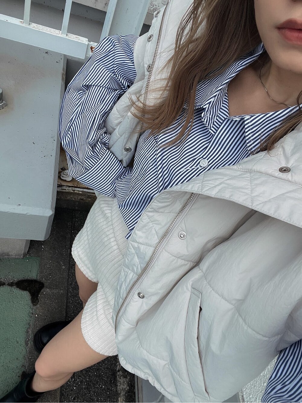 ブルー系のシャツ/ブラウス、ホワイト系のダウンベストを着用したレディースの秋コーディネートの8枚目の写真