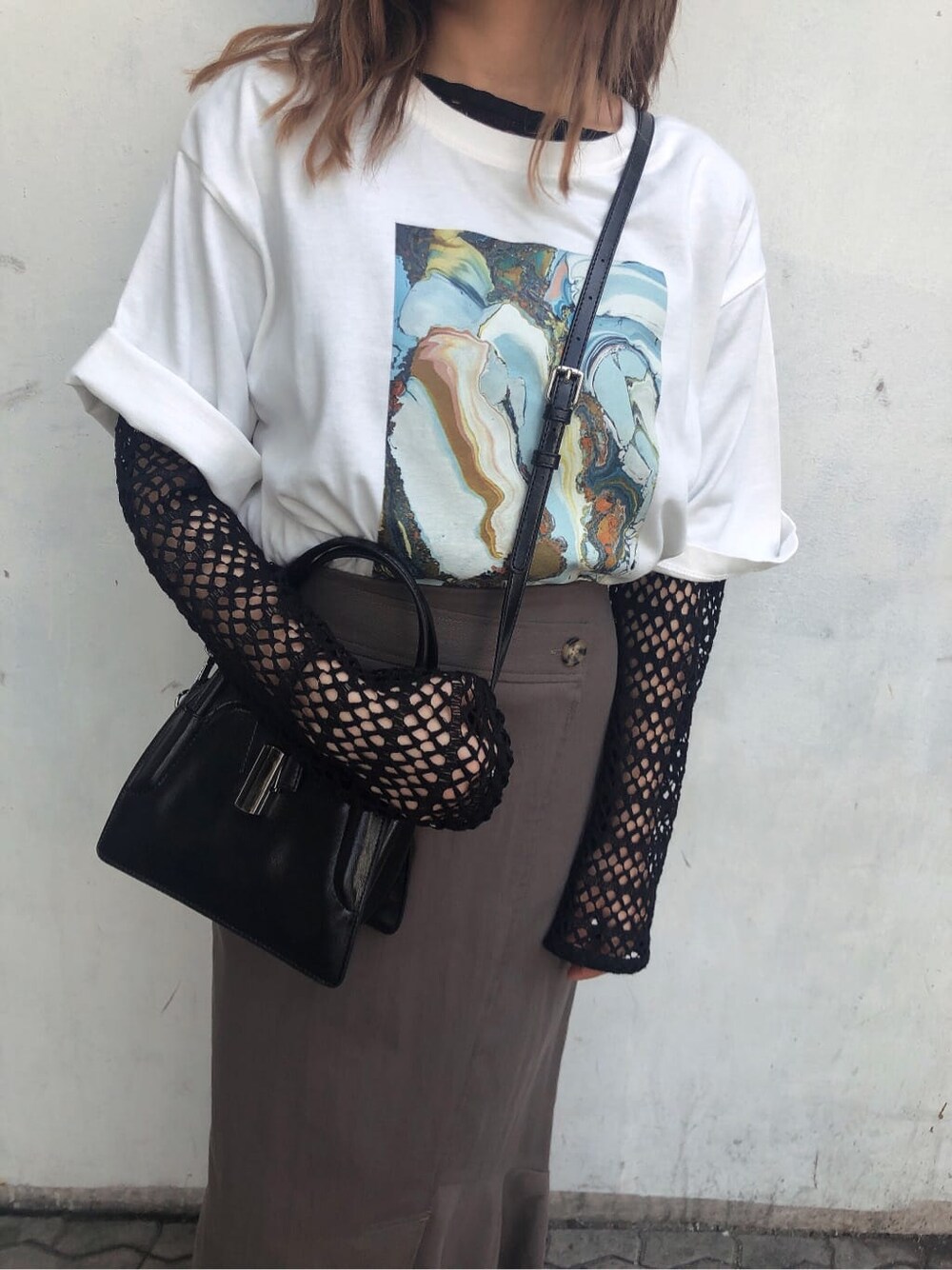 グレー系のスカート、ブラック系のハンドバッグ、ホワイト系のTシャツ/カットソーを着用したレディースの春コーディネートの7枚目の写真