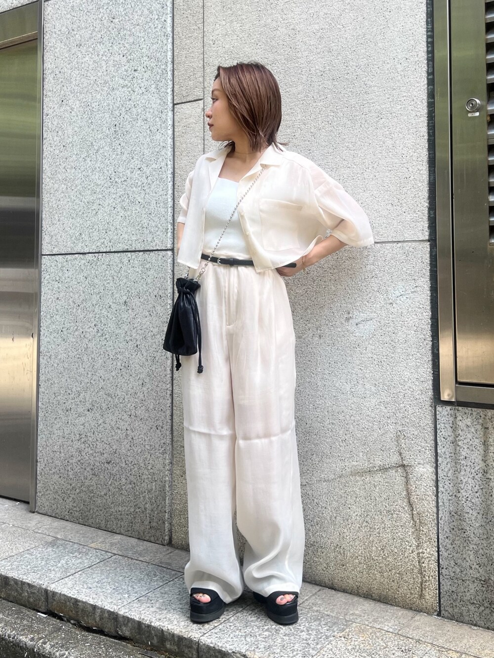 ホワイト系のシャツ/ブラウス、ホワイト系のニット/セーター、ブラック系のショルダーバッグを着用したレディースの夏コーディネートの4枚目の写真