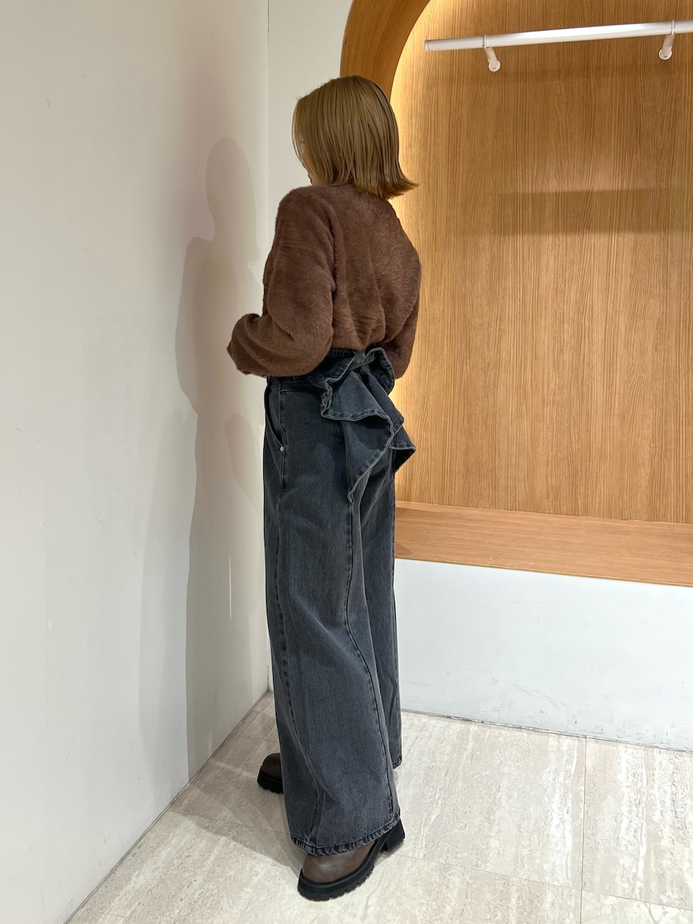 ブラウン系のカーディガン/ボレロ、ブラック系のデニムパンツ、ブラウン系のブーツを着用したレディースの冬コーディネートの2枚目の写真