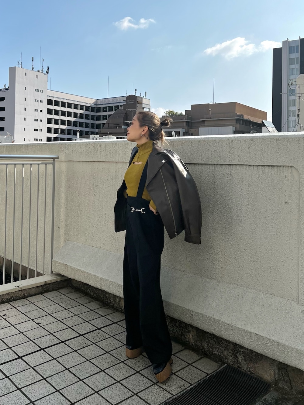 ブラウン系のライダースジャケット、ブラック系のスラックス、ブラック系のローファーを着用したレディースの秋コーディネートの2枚目の写真