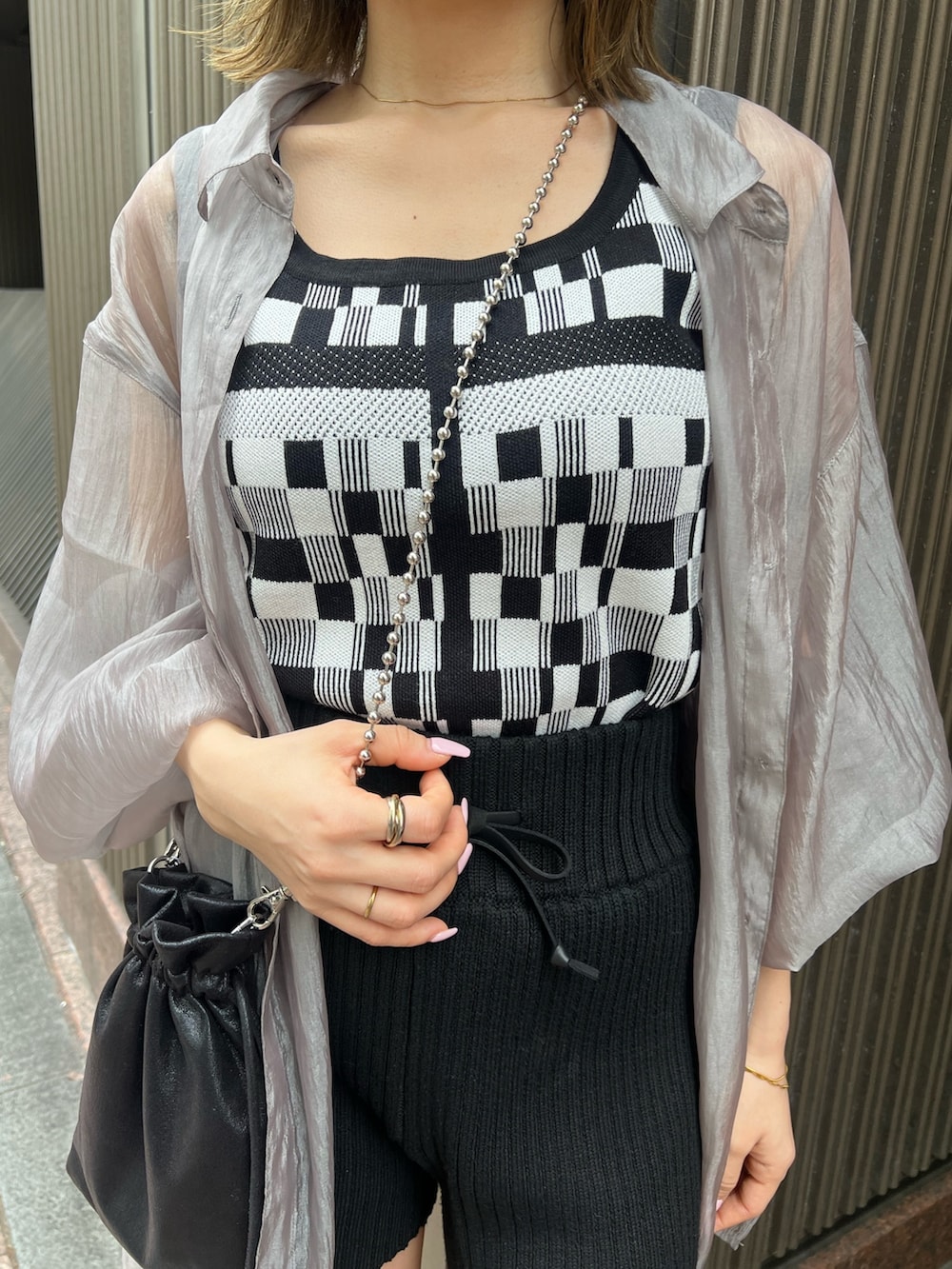 ブラック系のタンクトップ、ブラック系のその他パンツ、ブラック系のショルダーバッグを着用したレディースの春コーディネートの6枚目の写真