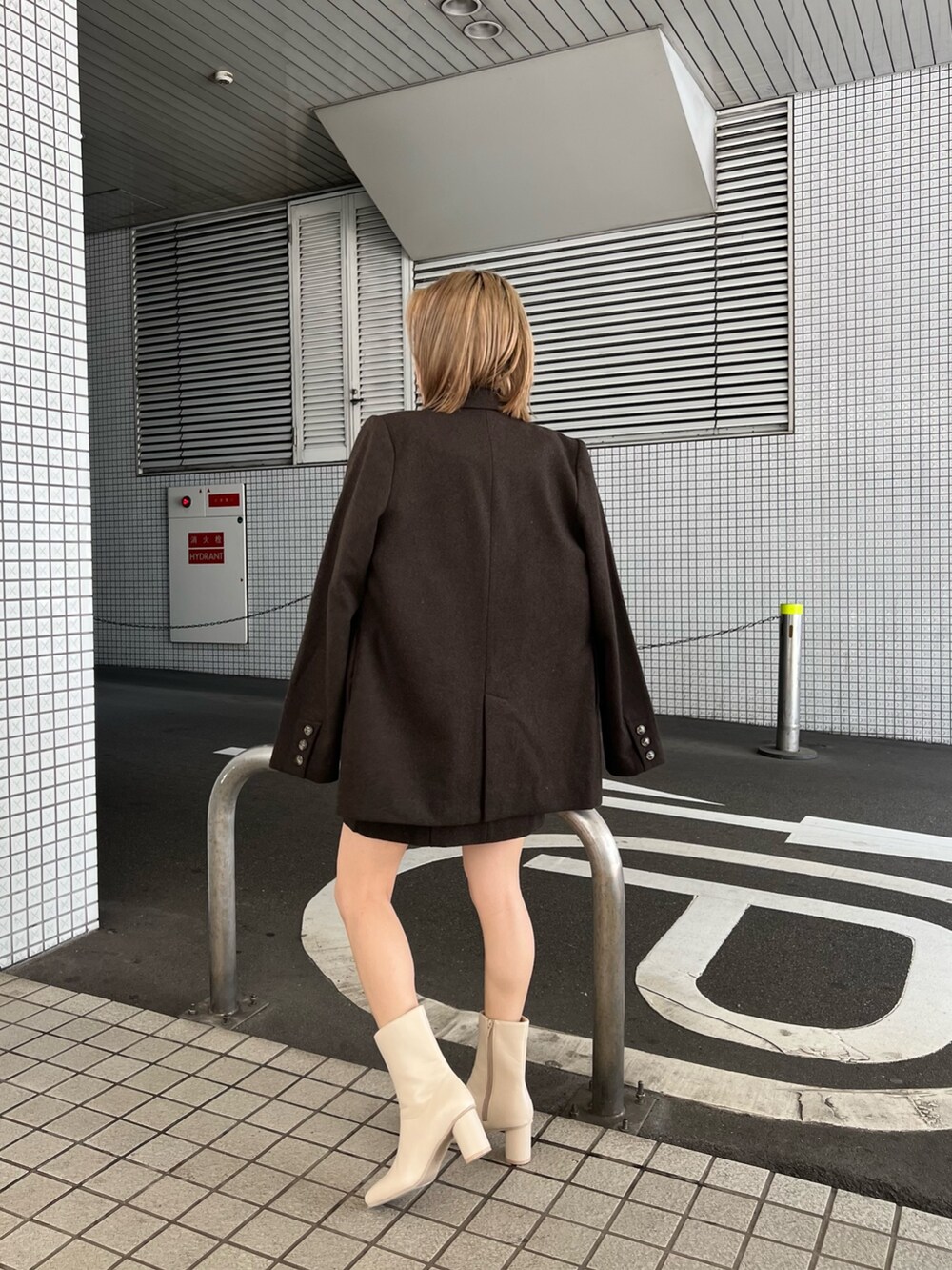 ホワイト系のニット/セーター、ホワイト系のブーツ、ブラウン系のテーラードジャケットを着用したレディースの秋コーディネートの3枚目の写真