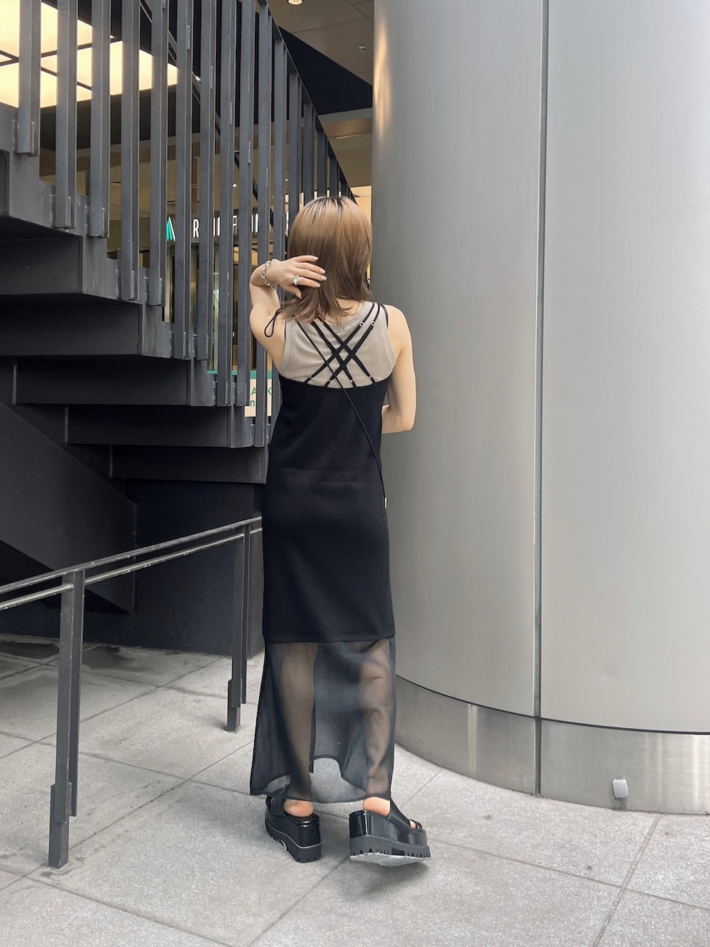 ブラック系のサンダル、ベージュ系のTシャツ/カットソー、ブラック系のワンピースを着用したレディースの夏コーディネートの2枚目の写真