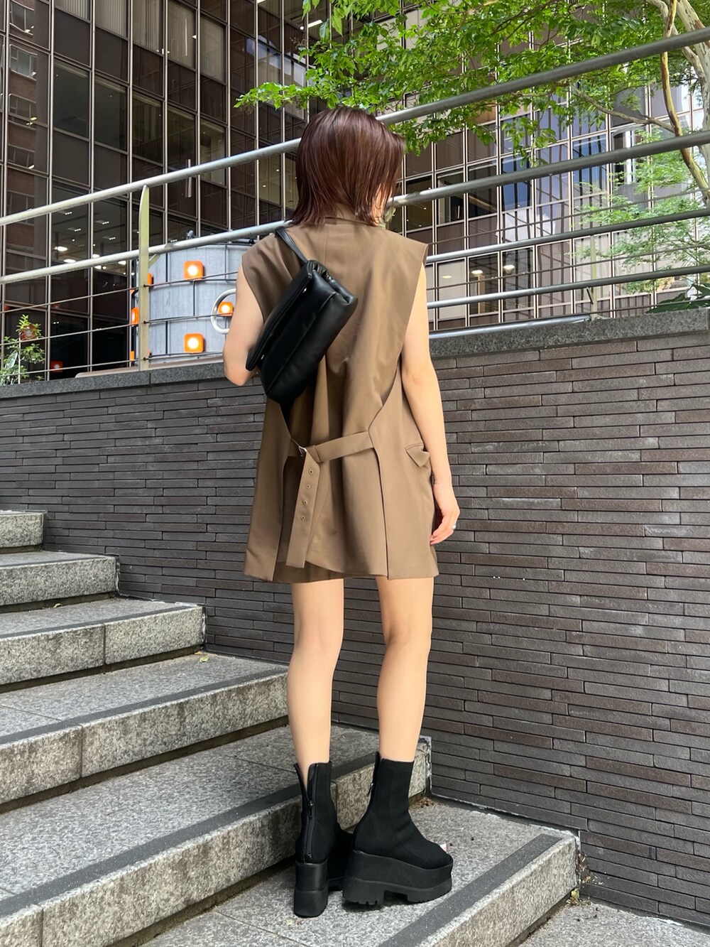 ブラウン系のベスト、ブラウン系のスカート、ホワイト系のニット/セーターを着用したレディースの夏コーディネートの2枚目の写真