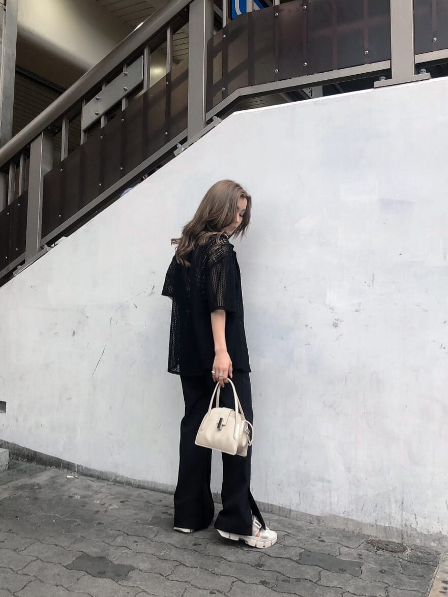 ブラック系のスラックス、ホワイト系のサンダル、ブラック系のシャツ/ブラウスを着用したレディースの春コーディネートの3枚目の写真