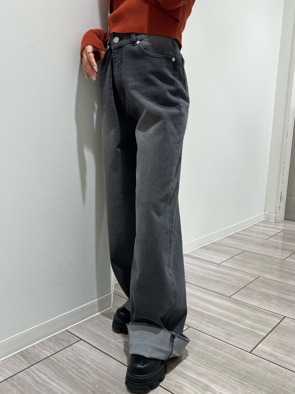 オレンジ系のニット/セーター、グレー系のデニムパンツを着用したレディースの冬コーディネートの8枚目の写真