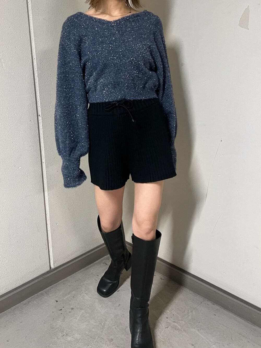 ブルー系のニット/セーター、グレー系のムートンコート、ブラック系のその他パンツを着用したレディースの秋コーディネートの8枚目の写真