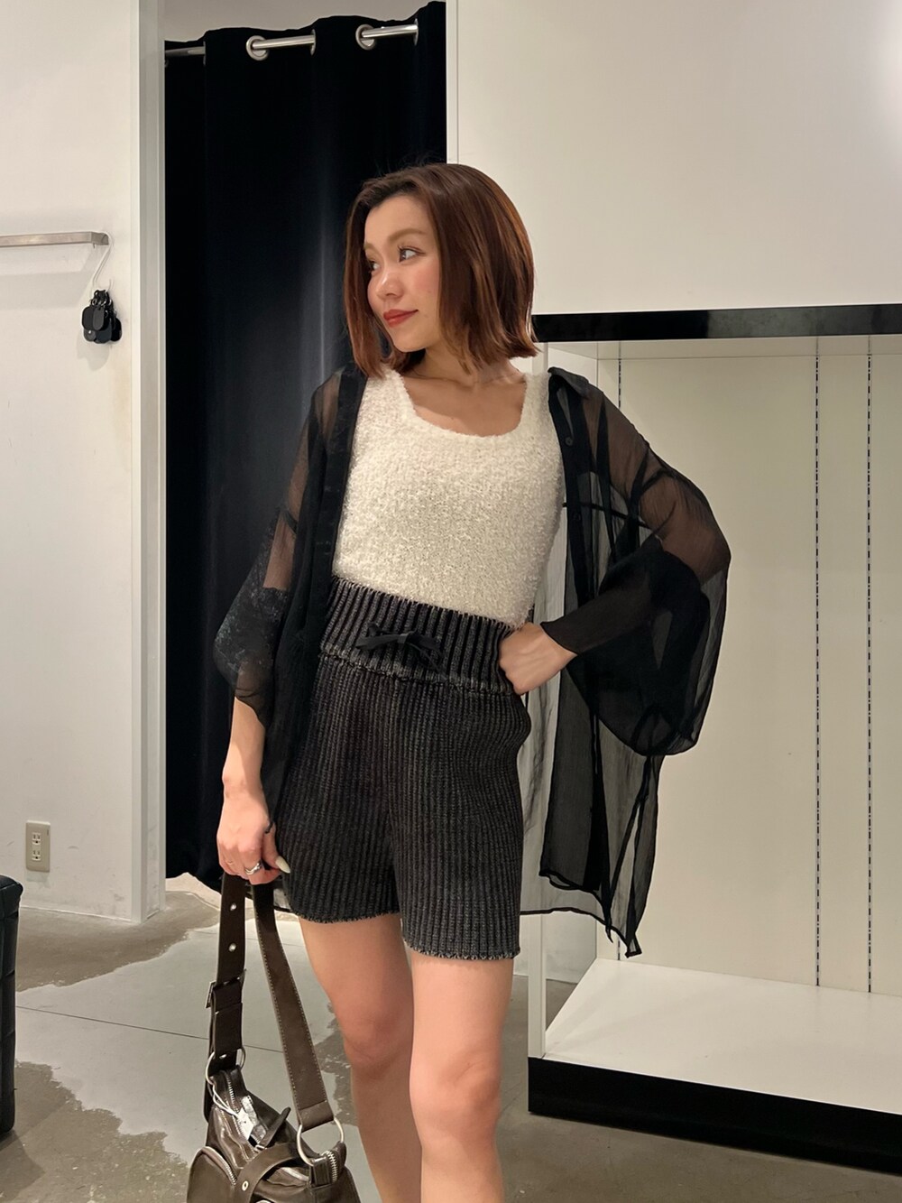 ブラック系のシャツ/ブラウス、ホワイト系のニット/セーター、ブラウン系のハンドバッグを着用したレディースの夏コーディネートの5枚目の写真