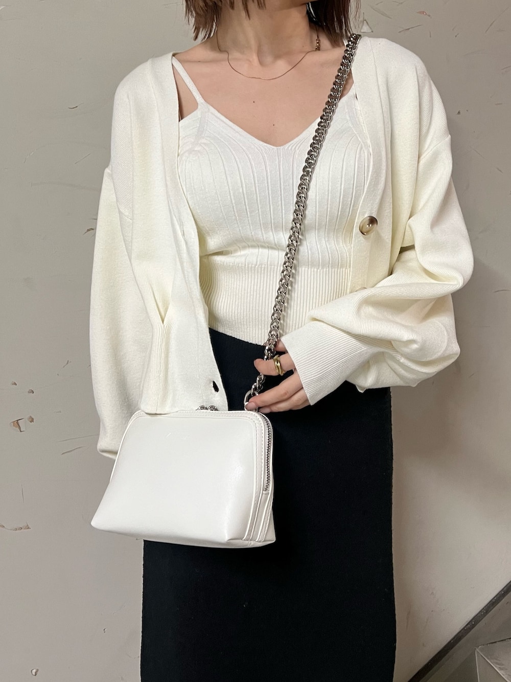 ホワイト系のブーツ、ブラック系のスカート、ホワイト系のカーディガン/ボレロを着用したレディースの冬コーディネートの8枚目の写真