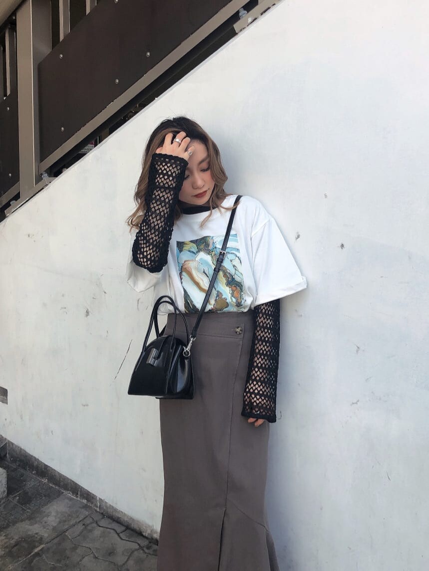グレー系のスカート、ブラック系のハンドバッグ、ホワイト系のTシャツ/カットソーを着用したレディースの春コーディネートの3枚目の写真