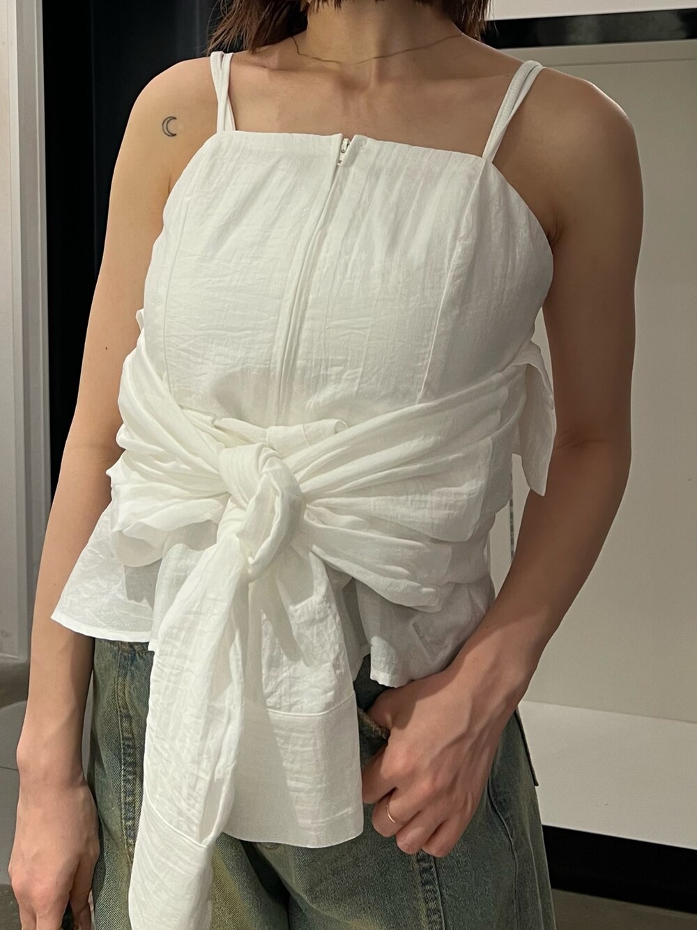 ホワイト系のシャツ/ブラウス、ブルー系のデニムパンツ、シルバー系のパンプスを着用したレディースの夏コーディネートの7枚目の写真