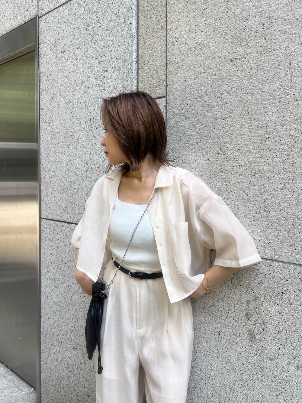 ホワイト系のシャツ/ブラウス、ホワイト系のニット/セーター、ブラック系のショルダーバッグを着用したレディースの夏コーディネートの5枚目の写真