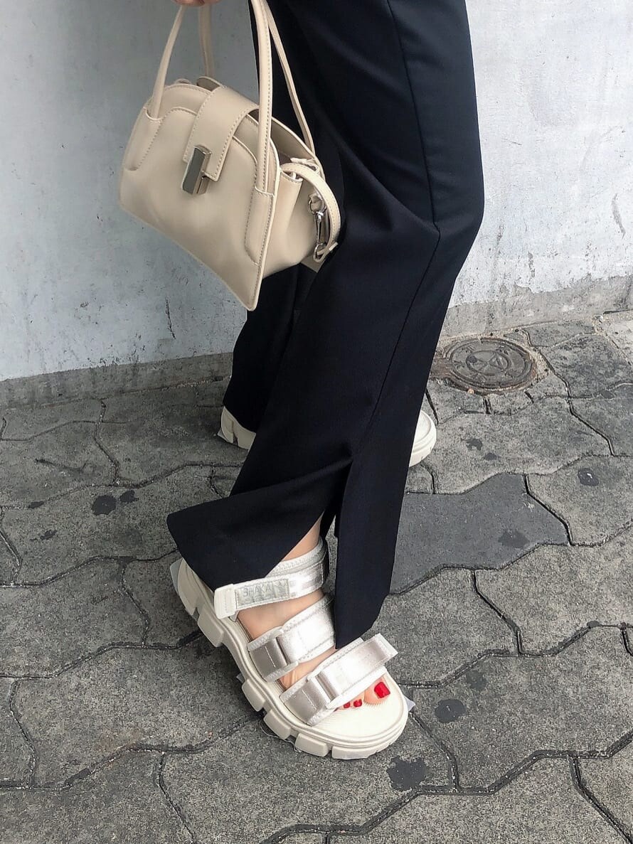 ブラック系のスラックス、ホワイト系のサンダル、ブラック系のシャツ/ブラウスを着用したレディースの春コーディネートの8枚目の写真