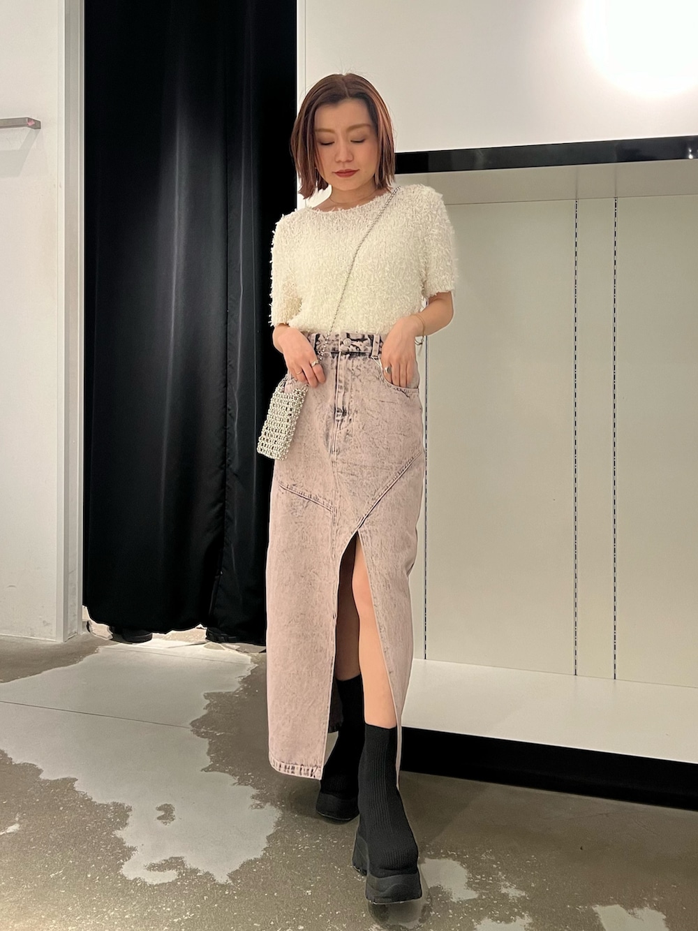 ホワイト系のニット/セーター、ピンク系のデニムスカート、ブラック系のブーツを着用したレディースの春コーディネートの4枚目の写真