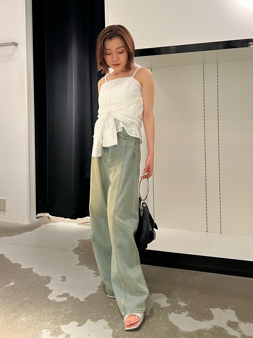 ホワイト系のシャツ/ブラウス、ブルー系のデニムパンツ、シルバー系のパンプスを着用したレディースの夏コーディネートの2枚目の写真