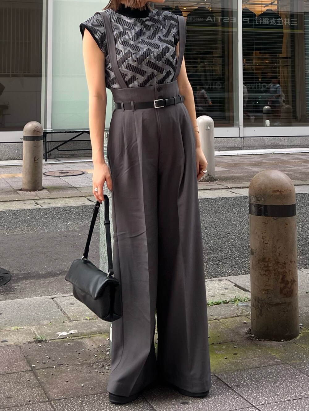 ブラック系のニット/セーター、グレー系のその他パンツ、ブラック系のハンドバッグを着用したレディースの夏コーディネートの4枚目の写真