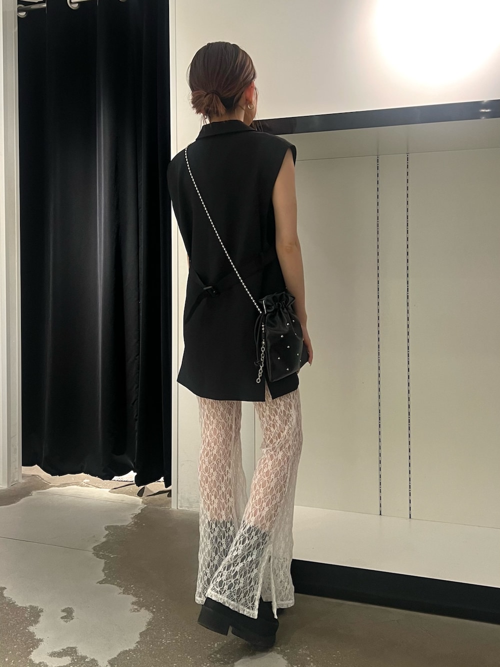 ブラック系のベスト、ホワイト系のその他パンツ、ブラック系のサンダルを着用したレディースの春コーディネートの2枚目の写真