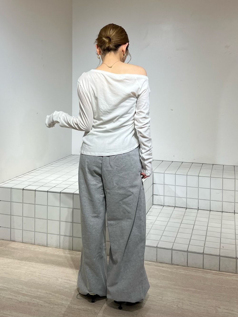 ホワイト系のTシャツ/カットソー、グレー系のその他パンツ、ブラック系のサンダルを着用したレディースの春コーディネートの3枚目の写真