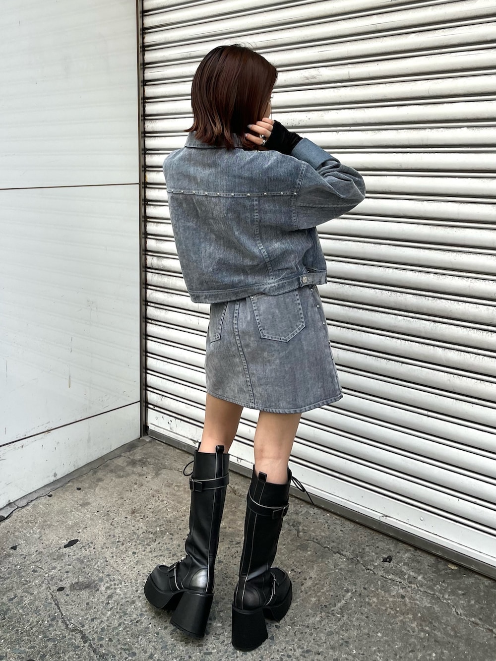 ブラック系のブーツ、ブラック系のTシャツ/カットソー、グレー系のデニムジャケットを着用したレディースの夏コーディネートの3枚目の写真