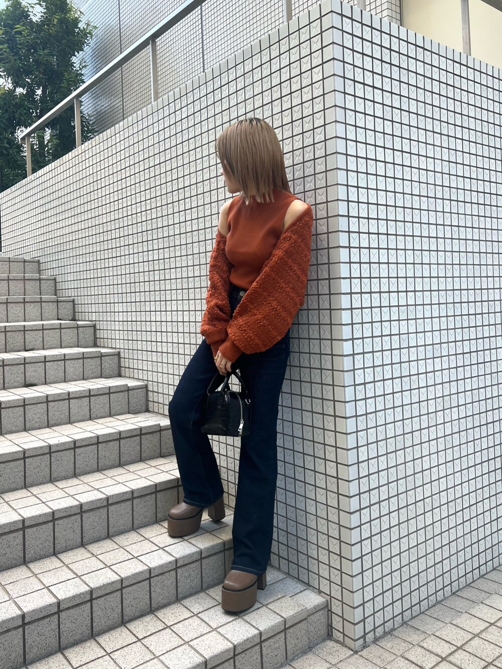 オレンジ系のカーディガン/ボレロ、ブルー系のデニムパンツ、ブラウン系のブーツを着用したレディースの夏コーディネートの5枚目の写真