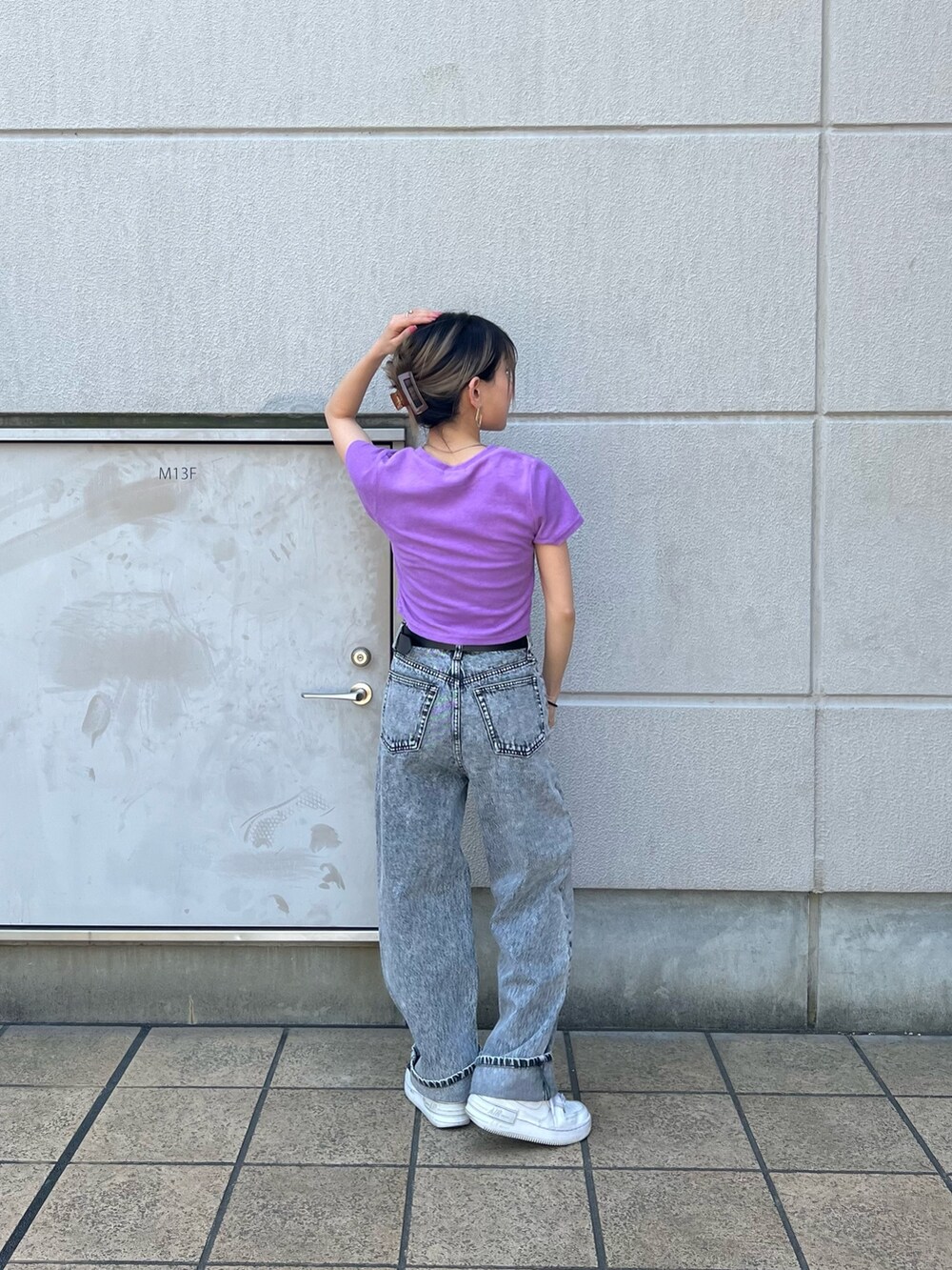 グレー系のデニムパンツ、パープル系のTシャツ/カットソー、ブラック系のベルトを着用したレディースの春コーディネートの3枚目の写真